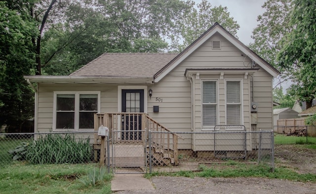 501 W Center Ave, Springdale, AR 72764 - bungalow with a fenced front yard, a shingled roof, and a gate