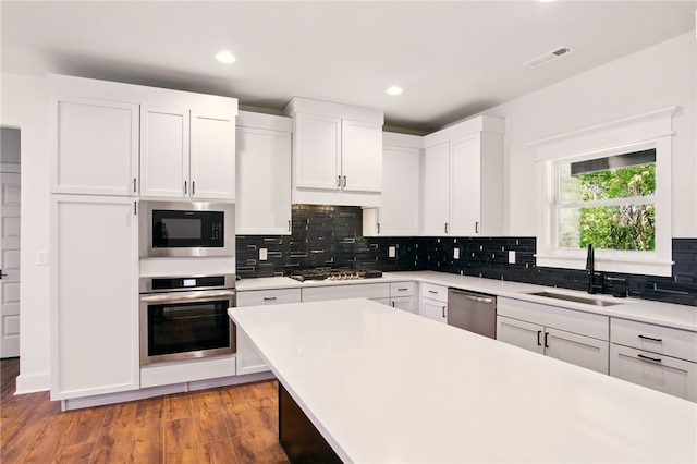 4551 Gibson St, Springdale, AR 72762 - kitchen with stainless steel appliances, a sink, light countertops, white cabinetry, and backsplash