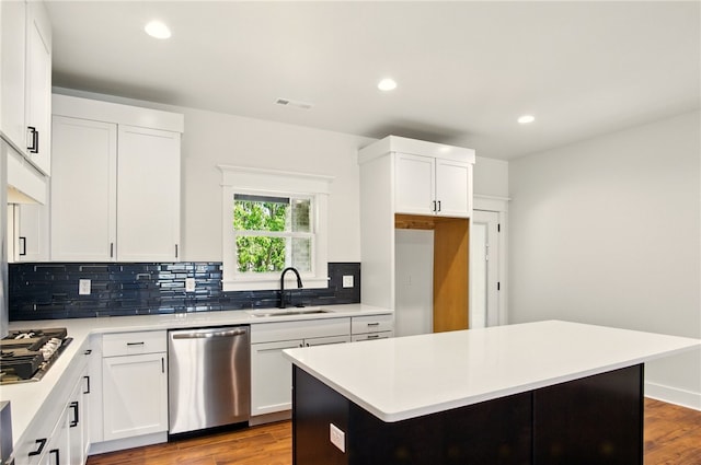 4551 Gibson St, Springdale, AR 72762 - kitchen with appliances with stainless steel finishes, a sink, tasteful backsplash, light countertops, and wood finished floors