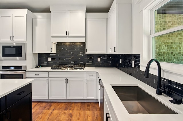 4551 Gibson St, Springdale, AR 72762 - kitchen featuring a sink, appliances with stainless steel finishes, white cabinetry, and light countertops