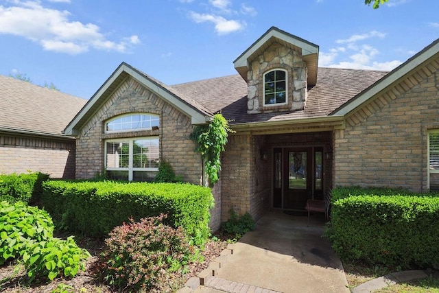 4007 W Song Bird Pl, Fayetteville, AR 72704 - entrance to property featuring stone siding, roof with shingles, and brick siding