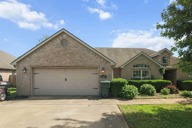 4007 W Song Bird Pl, Fayetteville, AR 72704 - view of front of house featuring brick siding, driveway, an attached garage, and roof with shingles