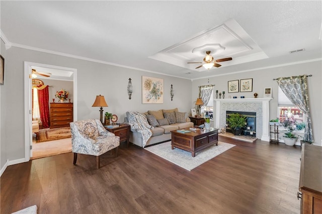 1480 Dallas St, Gravette, AR 72736 - living room featuring a raised ceiling, ceiling fan, dark wood-style flooring, a fireplace, and ornamental molding