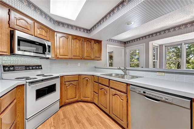 22 Marina Cir, Bella Vista, AR 72715 - kitchen with appliances with stainless steel finishes, a sink, light wood finished floors, backsplash, and light countertops