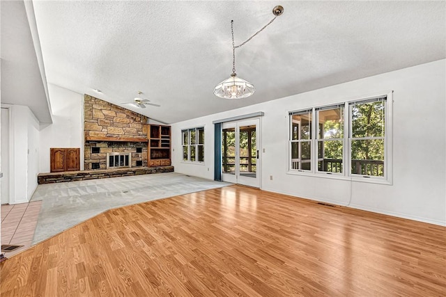 22 Marina Cir, Bella Vista, AR 72715 - unfurnished living room featuring a textured ceiling, ceiling fan, lofted ceiling, wood finished floors, and a fireplace