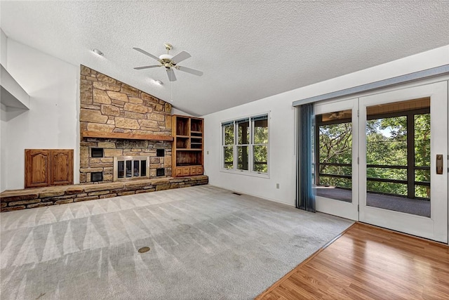 22 Marina Cir, Bella Vista, AR 72715 - unfurnished living room featuring a textured ceiling, a ceiling fan, vaulted ceiling, wood finished floors, and a fireplace