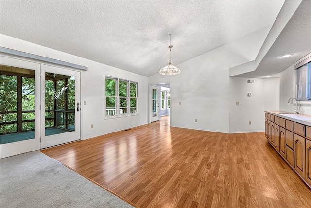 22 Marina Cir, Bella Vista, AR 72715 - unfurnished dining area featuring a sink, healthy amount of natural light, light wood-style floors, a textured ceiling, and vaulted ceiling