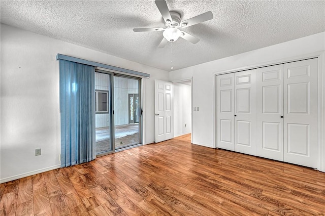 22 Marina Cir, Bella Vista, AR 72715 - unfurnished bedroom featuring a textured ceiling, wood finished floors, baseboards, a ceiling fan, and access to outside