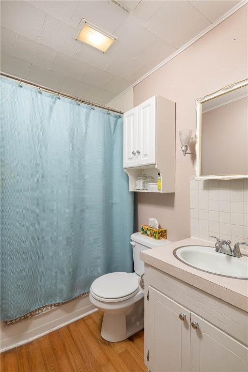 1600 Westwood Ave, Springdale, AR 72762 - full bathroom featuring toilet, vanity, backsplash, wood finished floors, and shower / bath combo