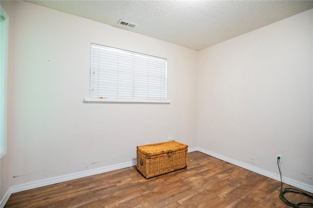 1125 E Elm St, Fayetteville, AR 72703 - spare room with wood finished floors, baseboards, and a textured ceiling