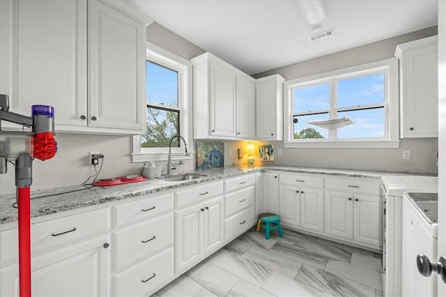 1699 E Bowen Blvd, Fayetteville, AR 72703 - kitchen with a sink, separate washer and dryer, white cabinetry, and light stone countertops