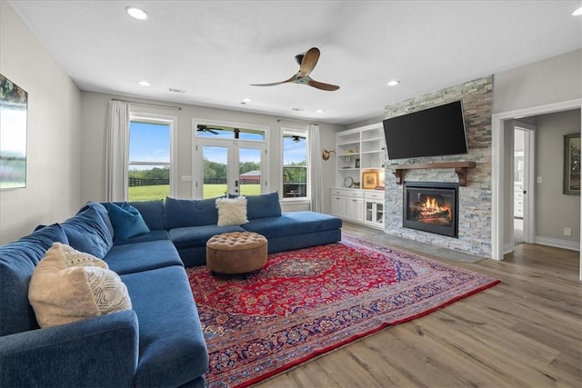 1699 E Bowen Blvd, Fayetteville, AR 72703 - living room with wood finished floors, french doors, a stone fireplace, a ceiling fan, and recessed lighting