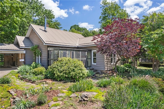 324 E Sutton St, Fayetteville, AR 72701 - view of front facade with a carport, metal roof, and a sunroom