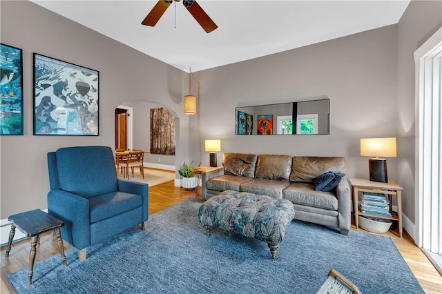 324 E Sutton St, Fayetteville, AR 72701 - living room featuring a ceiling fan, wood finished floors, arched walkways, and baseboards