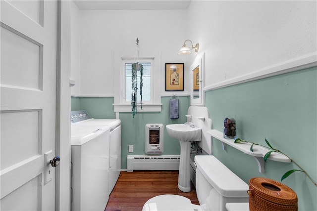 324 E Sutton St, Fayetteville, AR 72701 - half bath with a baseboard heating unit, washer and dryer, toilet, heating unit, and wood finished floors