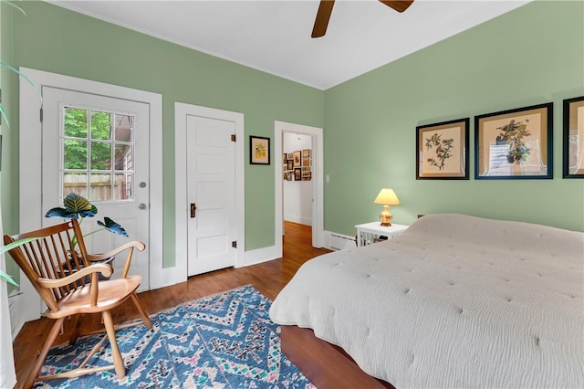 324 E Sutton St, Fayetteville, AR 72701 - bedroom featuring wood finished floors, a baseboard radiator, baseboards, and ceiling fan