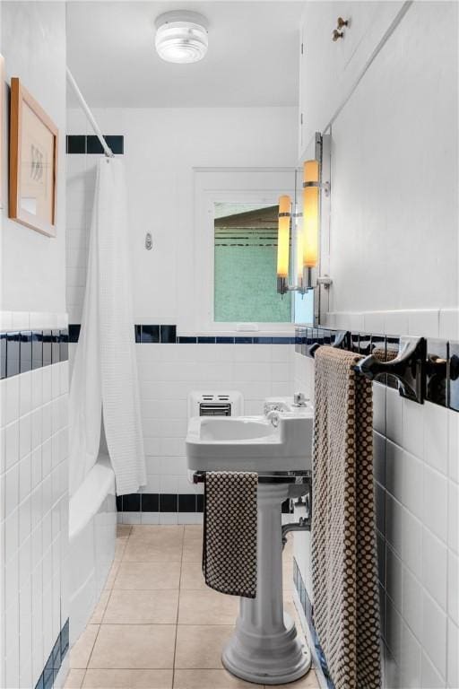 324 E Sutton St, Fayetteville, AR 72701 - full bath featuring tile walls, tile patterned floors, shower / bathtub combination with curtain, and a wainscoted wall