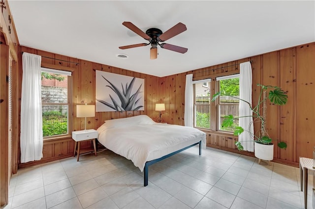 324 E Sutton St, Fayetteville, AR 72701 - bedroom featuring multiple windows, wooden walls, and ceiling fan