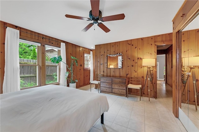 324 E Sutton St, Fayetteville, AR 72701 - bedroom featuring wooden walls, light tile patterned flooring, and a ceiling fan