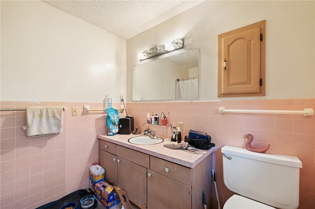 7 Ipswich Dr, Bella Vista, AR 72714 - bathroom featuring a textured ceiling, vanity, tile walls, toilet, and wainscoting