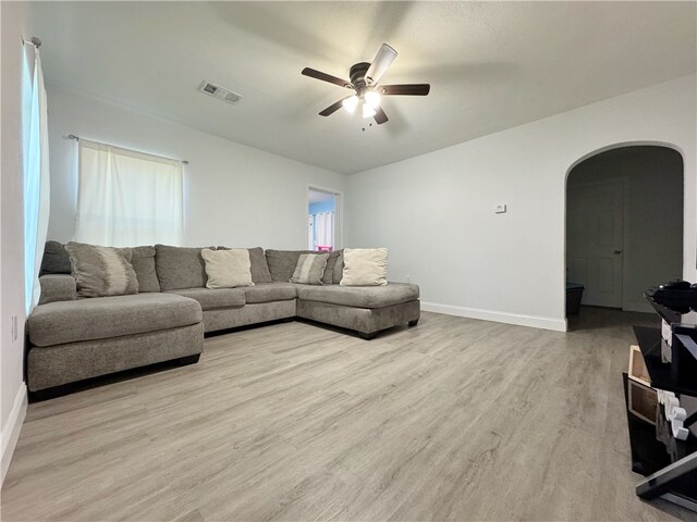 1105 Gibson St, Ozark, AR 72949 - living area with arched walkways, ceiling fan, light wood-style flooring, and baseboards