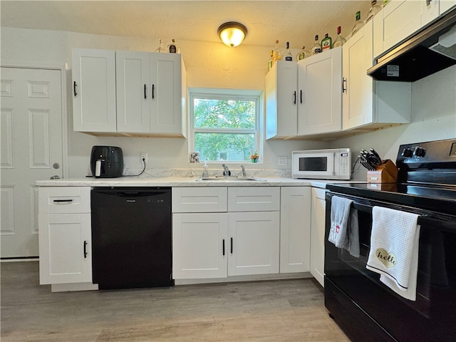 1105 Gibson St, Ozark, AR 72949 - kitchen featuring black appliances, under cabinet range hood, a sink, light wood finished floors, and white cabinetry