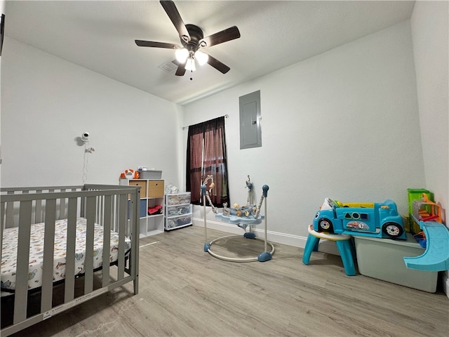 1105 Gibson St, Ozark, AR 72949 - bedroom with electric panel, wood finished floors, a nursery area, baseboards, and a ceiling fan