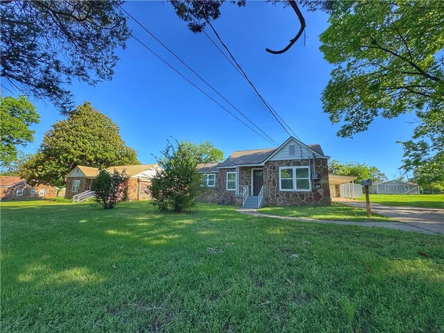 1105 Gibson St, Ozark, AR 72949 - view of front of property featuring stone siding, a front yard, an attached carport, and driveway
