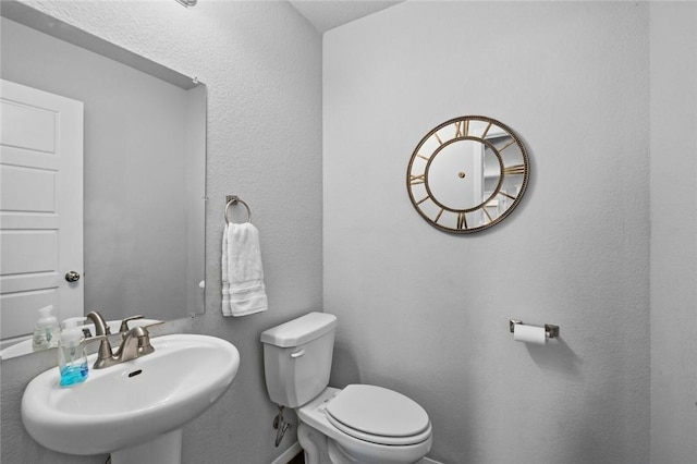 904 SW Loudon Dr, Bentonville, AR 72712 - bathroom with a sink, toilet, and baseboards