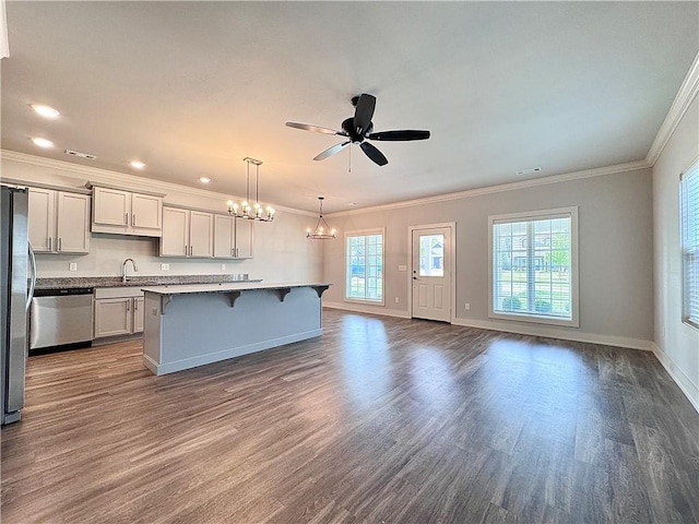 833 NE Heights Ln, Bentonville, AR 72712 - kitchen with stainless steel appliances, a breakfast bar area, dark wood-style floors, crown molding, and baseboards