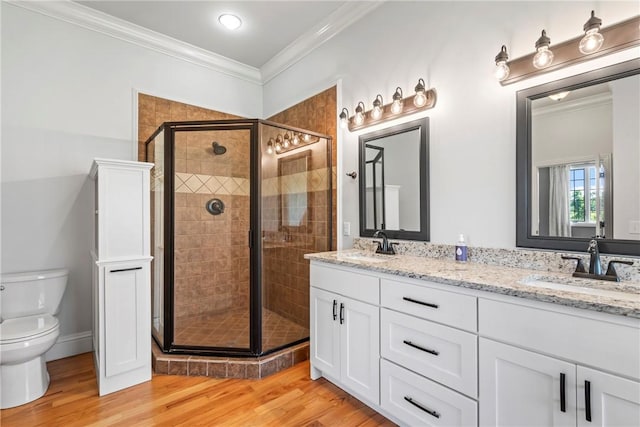 15071 Crossover Rd, Gravette, AR 72736 - bathroom featuring double vanity, toilet, a stall shower, wood finished floors, and crown molding