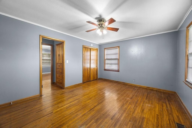 713 Young St, Springdale, AR 72764 - unfurnished bedroom featuring hardwood / wood-style floors, crown molding, a closet, baseboards, and a ceiling fan