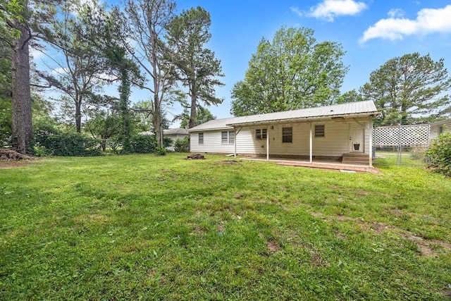 713 Young St, Springdale, AR 72764 - rear view of house with a yard, metal roof, and a patio area