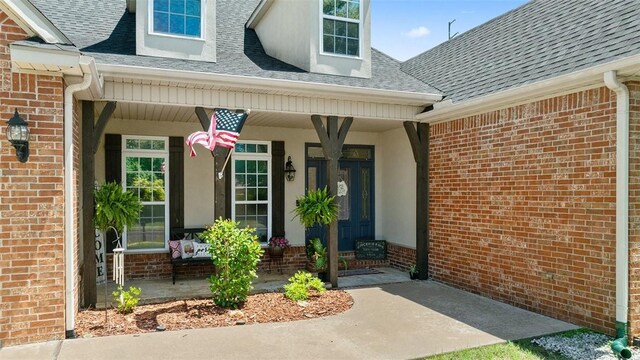 1051 Thornridge Rd, Bentonville, AR 72713 - entrance to property with brick siding, covered porch, and roof with shingles