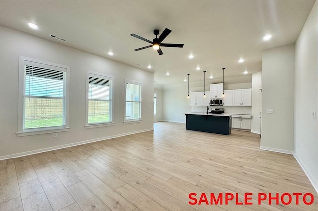 5902 SW Desert Ave, Bentonville, AR 72713 - unfurnished living room with a ceiling fan, light wood-style flooring, baseboards, and recessed lighting