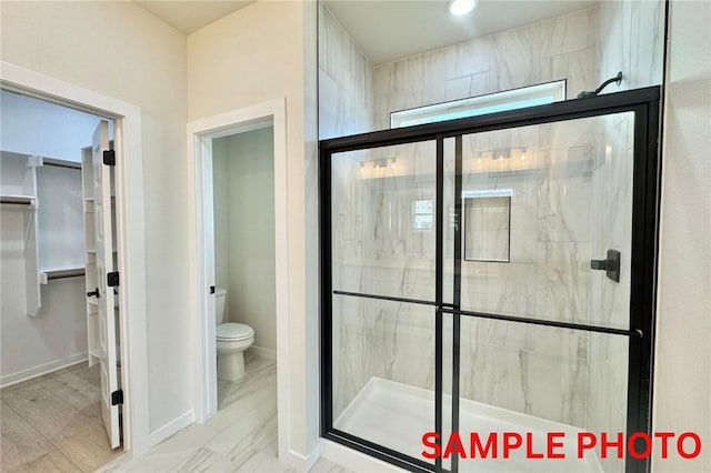 5902 SW Desert Ave, Bentonville, AR 72713 - bathroom featuring a marble finish shower, toilet, and baseboards