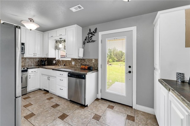 1630 S Dixieland Rd, Rogers, AR 72758 - kitchen featuring stainless steel appliances, a sink, dark countertops, and tasteful backsplash