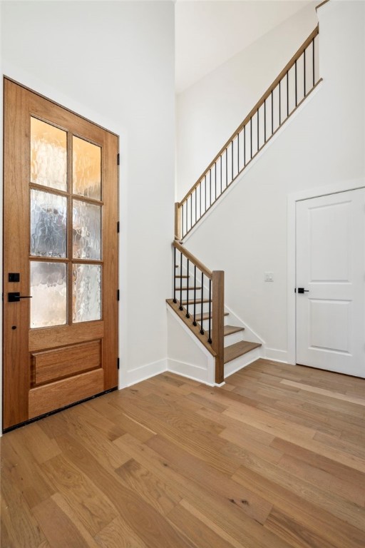10 Rushden Ln, Bella Vista, AR 72714 - entryway featuring light wood finished floors, stairs, a high ceiling, and baseboards