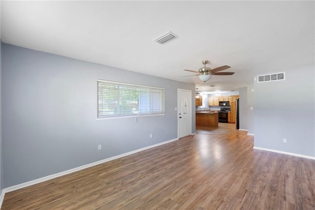 907 S Ithaca Ave, Russellville, AR 72801 - unfurnished living room featuring light wood-style flooring, ceiling fan, and baseboards