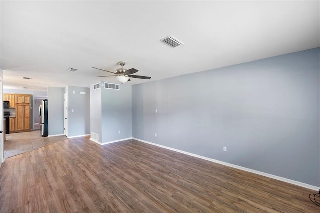907 S Ithaca Ave, Russellville, AR 72801 - unfurnished living room with ceiling fan, wood finished floors, and baseboards