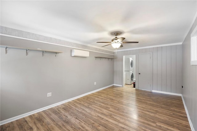 907 S Ithaca Ave, Russellville, AR 72801 - unfurnished bedroom with stacked washer / dryer, a wall unit AC, baseboards, wood finished floors, and ornamental molding
