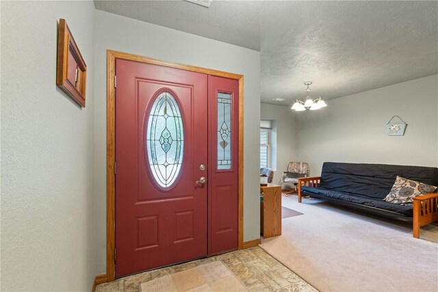 74 Twin Peak Dr, Holiday Island, AR 72631 - foyer entrance featuring a chandelier, baseboards, a textured ceiling, and light colored carpet