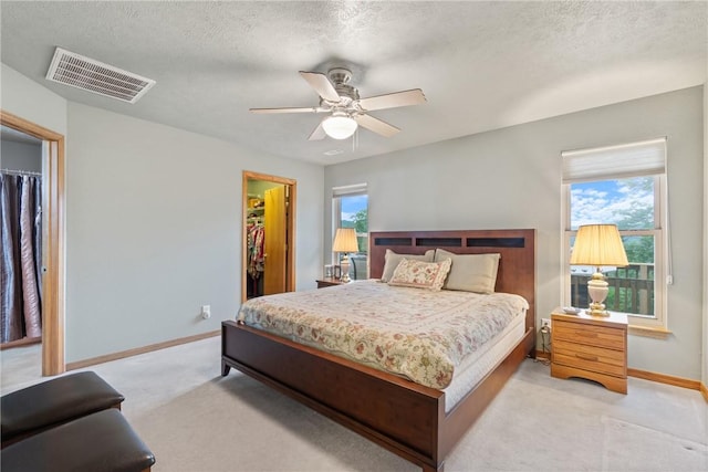 74 Twin Peak Dr, Holiday Island, AR 72631 - bedroom with a walk in closet, light carpet, baseboards, a closet, and a textured ceiling