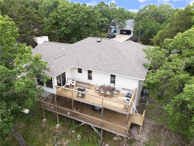 74 Twin Peak Dr, Holiday Island, AR 72631 - rear view of house featuring roof with shingles, outdoor dining space, a chimney, and a wooden deck