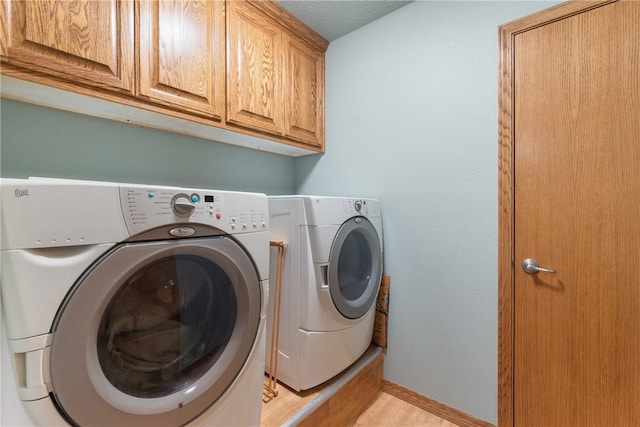 74 Twin Peak Dr, Holiday Island, AR 72631 - laundry room with independent washer and dryer, cabinet space, light wood-style flooring, and baseboards