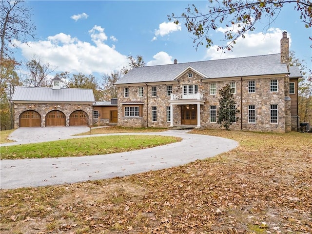 10760 Sugar Creek Rd, Bentonville, AR 72751 - view of front of house with stone siding, a chimney, curved driveway, and a front lawn