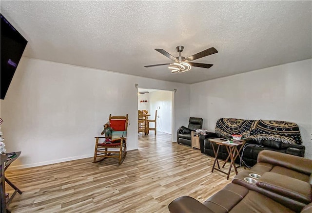 103 Mockingbird St, Harrison, AR 72601 - living area with light wood-style flooring, a textured ceiling, a ceiling fan, and baseboards