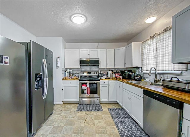 103 Mockingbird St, Harrison, AR 72601 - kitchen featuring appliances with stainless steel finishes, a sink, wooden counters, a textured ceiling, and white cabinets