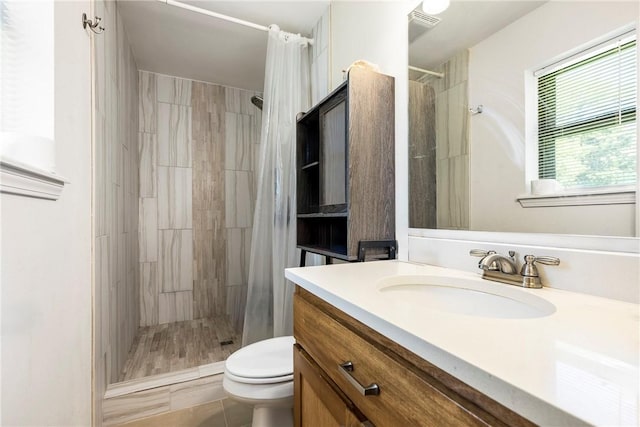 909 11th St, Bentonville, AR 72712 - bathroom with vanity, toilet, and a tile shower