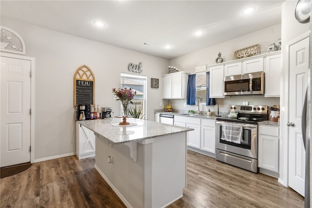5003 W Claxton Cir, Fayetteville, AR 72704 - kitchen with stainless steel appliances, a sink, white cabinetry, light stone counters, and recessed lighting